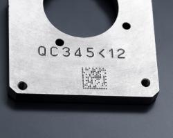Componente metallico inciso mediante micropercussione con un numero di serie e un codice Datamatrix.
