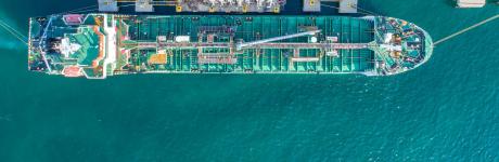 Top-down view of cargo ship being refueled and loaded