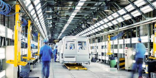 Linea di produzione automobilistica con carrozzerie e operatori al lavoro nella zona di assemblaggio