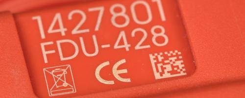 Marcatura Datamatrix su una parte in plastica rossa con incisione del riferimento e dei simboli CE