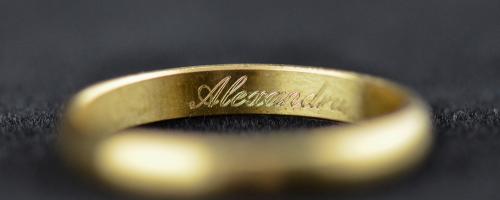 Incisione all'interno dell'anello del nome Alexandra su una fede nuziale in oro