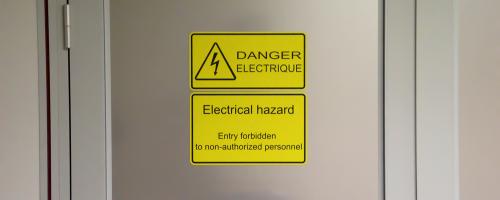 Incisione laser della segnaletica di sicurezza in Gravoply™ Laser su una porta industriale per la sicurezza sul lavoro